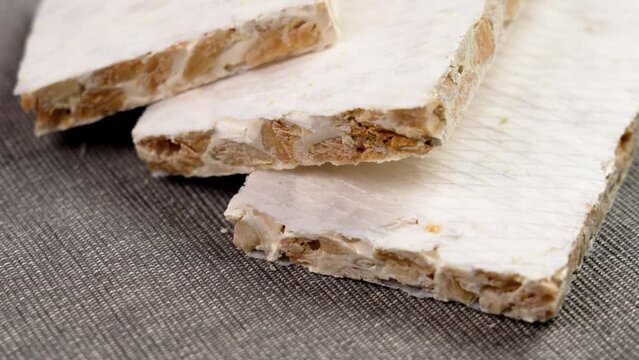 Pieces of typical Spanish almond hard turron. European delicious nutty nougat. Rotation