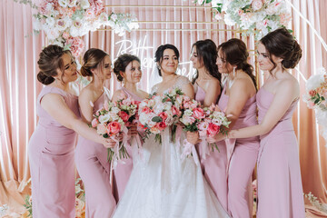 Group portrait of the bride and bridesmaids. Bride in a wedding dress and bridesmaids in pink or...