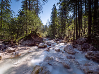 View to a wild water river at the Berchtesgaden forest during summer time 