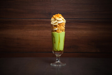 a glass of avocado banana cornflakes healthy drink  on a wooden background