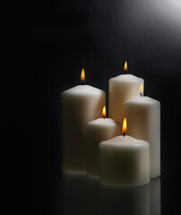 White candles over black background