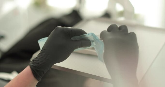 Close-up of dentist's hands holding dental tools and toothpaste. The use of sterile materials and the process of professional teeth cleaning in a dental clinic.