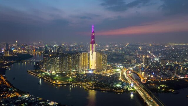 Forwards fly above modern metropolis with illuminated skyscrapers and busy highway. Beautiful hyperlapse footage of sunset. Saigon Hochiminh City, Vietnam stock video.	