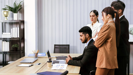 Diverse colleagues Asian and Caucasian working group meeting on project together, using laptop, sitting in office, discussing strategy and brainstorming. Multiracial business people in meeting concept