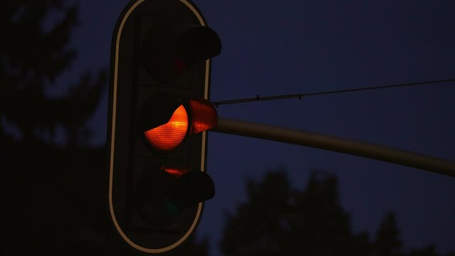 Traffic light works at night time. Close up. Full cycle from green to red signal. Regulations and driving safety concept. Night city traffic control