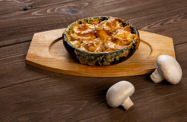 Julienne with cheese  and champignons on a wooden table. Homemade food. Healthy eating.