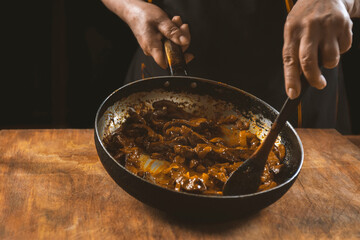 The cook prepares meat with vegetables and onion in a bowl . Oriental cuisine