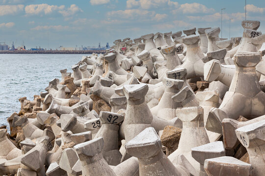 A breakwater made of concrete structures of tetrapods is installed in the sea.