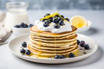 Low sugar, healthy breakfast dish: stack of lemon poppy seed pancakes with yogurt and blueberries. - obrazy, fototapety, plakaty