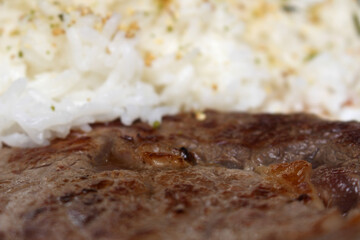 steak with rice. meat with rice. beef with white rice. food with selective focus. texture of red meat prepared for meal.
