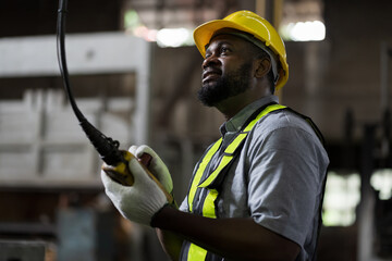 African American male engineer factory worker control heavy machine in the industry factory area....