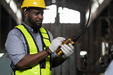 African American male engineer factory worker control heavy machine in the industry factory area....