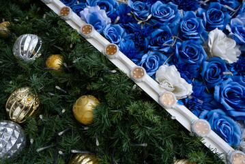 Closeup christmas Tree decorated with silver and gold color balls and Beautiful blue and white roses