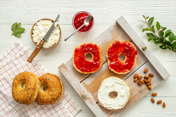 Baked bread bagels with with berry jam and cheese cream. Healthy breakfast background
