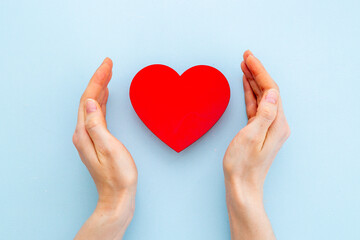 Red heart with woman hands, top view. Health care and love concept