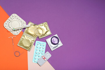 Contraceptive pills, condoms, intrauterine device and thermometer on color background, flat lay with space for text. Choice of birth control method