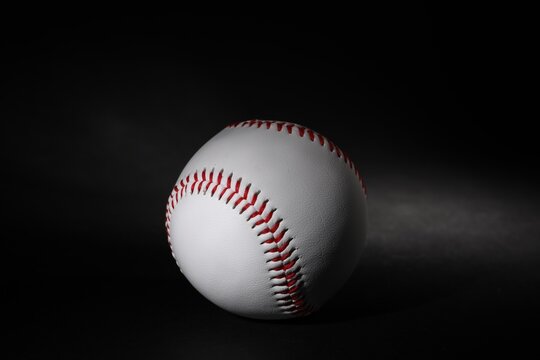 One leather baseball ball on black background