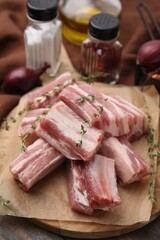 Cut raw pork ribs with thyme on table, closeup