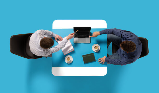 Creative collage. Aerial view of two confident man, entrepreneurs sitting at common table with document and laptop and discussing work tasks. Concept of business lunch, morning meeting, briefing. Ad