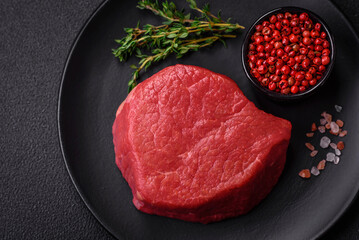 Fresh juicy raw filet mignon with salt, spices and herbs