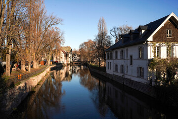 Fototapeta na wymiar Strasbourg, France - 18.12.2023 - Photo of the river and buildings in Strasbourg in December. Sunny weather. Calmness 