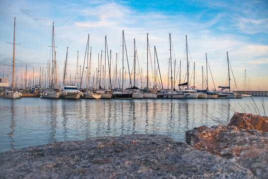 Sailboat harbor in the port evening photo. Beautiful moored sail yachts in the sea, modern water transport Barcelona