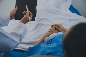 Asian Doctor make routine health check with patient in hospital ward