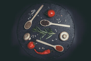 Raw vegetables and different spices on a black background, ingredients for the kitchen