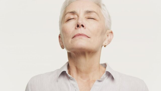 Serene Elderly Woman Deep Breath with Eyes Closed