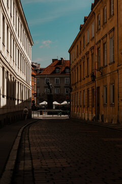 old street in Warsaw Poland dark shadows in a sunny day windows simetrical vertical composition