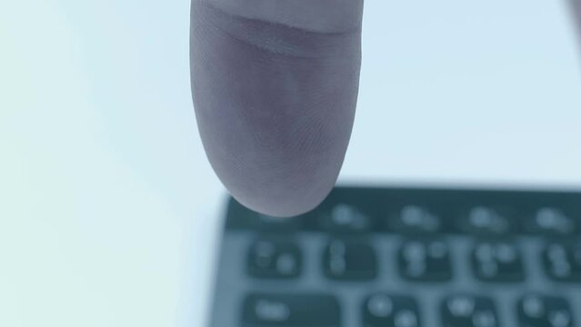 On a black computer keyboard, a finger presses the buttons: caps lock, delete, print screen, left arrow, up arrow, play and pause. Closeup. Macro. Shallow depth of field. Shot in motion