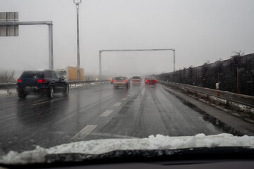 heavy snow during rush hour during snowy foggy winter day in Europe, carefully driving in bad...