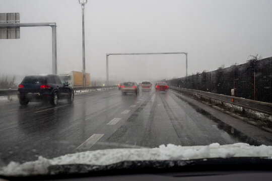 heavy snow during rush hour during snowy foggy winter day in Europe, carefully driving in bad weather condition 