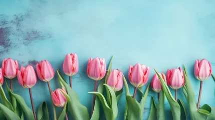 Tuinposter Border of beautiful pink tulips on blue shabby wallpaper background © SaraY Studio 