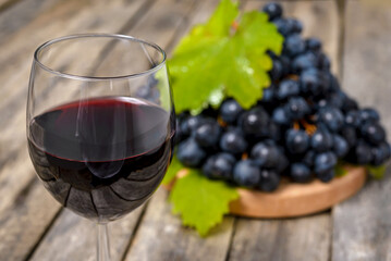 Red wine and grapes on wooden background