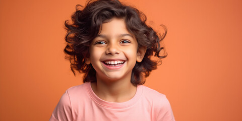 cute indian boy laughing on orange background - obrazy, fototapety, plakaty