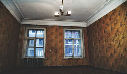 Living room aged interior of an abandoned communal apartment, tripped wallpaper, dirty rotten peeling walls. Background of old past of poor, cuffed floor. Repair renovation concept. Copy ad text space