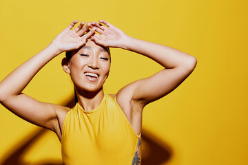 Woman portrait cheerful summer yellow beauty swimsuit trendy fashion smile surprised studio asian