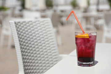 Pink and red Fresh colorful exotic alcoholic cocktail with lemon and ice on restaurant table....