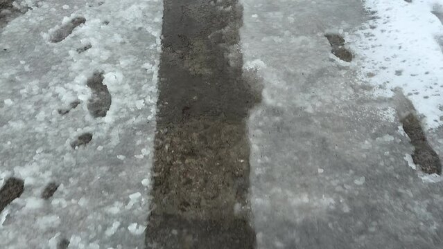 Traces of car tires and shoe sole footprints on sleet