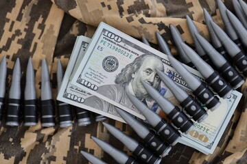 Bundles of dollars and a machine gun belt on the camouflage uniform of a Ukrainian soldier. Concept...