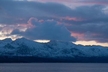 Purple and orange hues during a lightly clouded sunset over the arctic mountains