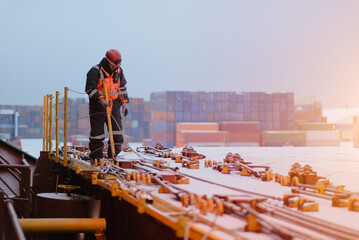 A Seafarer Walking On Deck Wearing Protective Safety Clothes and Distributing The Safety Handrails...