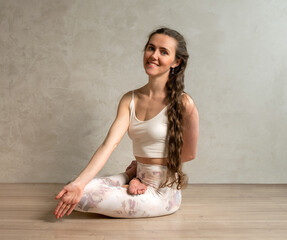junge Frau übt Körperhaltungungen imStudio, Yoga Ansanas für Kraft, Meditatin und innere Mitte