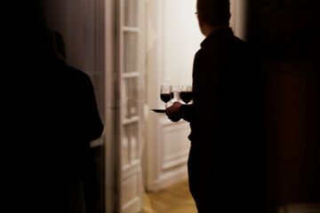 Silhouette holding wine glasses at a business event