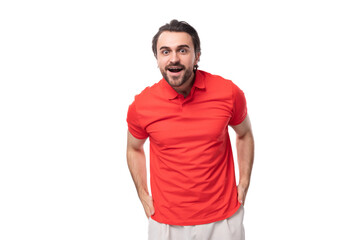 Fototapeta premium young handsome brunette man with a beard is dressed in a standard red t-shirt on a white background with copy space
