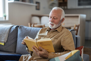 Relax, book and a senior man reading on couch in the living room of his home during retirement....