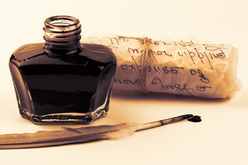 Inkwell and feather quill pen isolated on a white background. Glass bottle with mascara. Black liquid in a glass bottle. Parchment scroll isolated. Ancient paper scroll isolated on a white background.