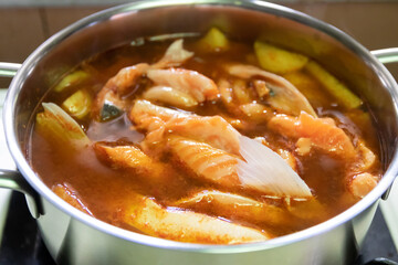 Pot of yellow curry with salmon and bamboo shoot thai southern style food.