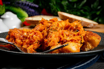 Fish in Greek kind with vegetables and tomato sauce.